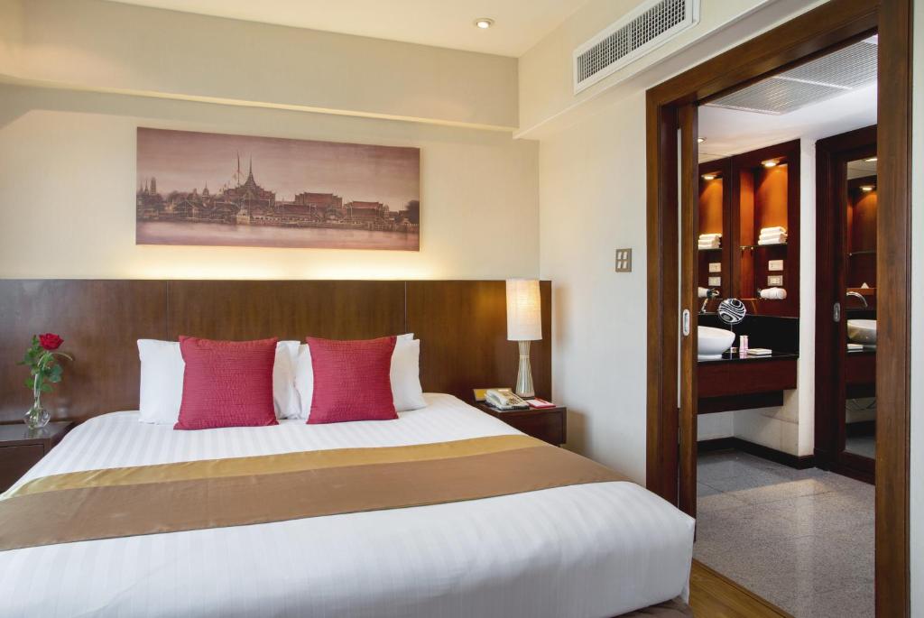 A compact king bedroom with a wood headboard and a bathroom doorway beside the bed.