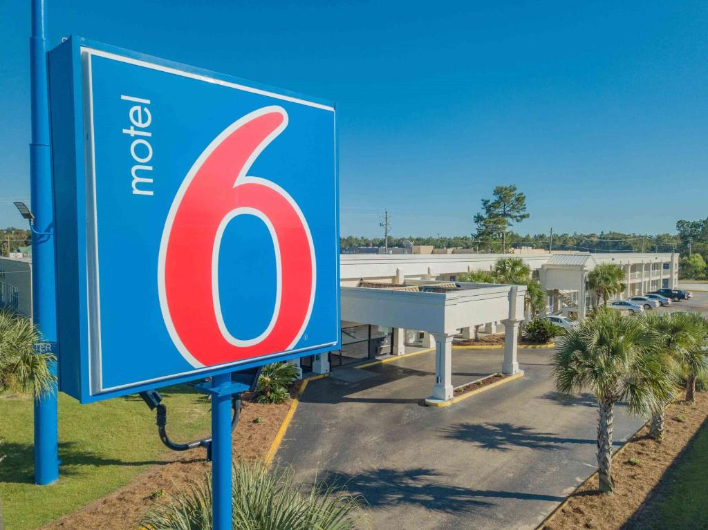 un letrero azul y rojo en un estacionamiento en Motel 6-Saraland, AL en Saraland