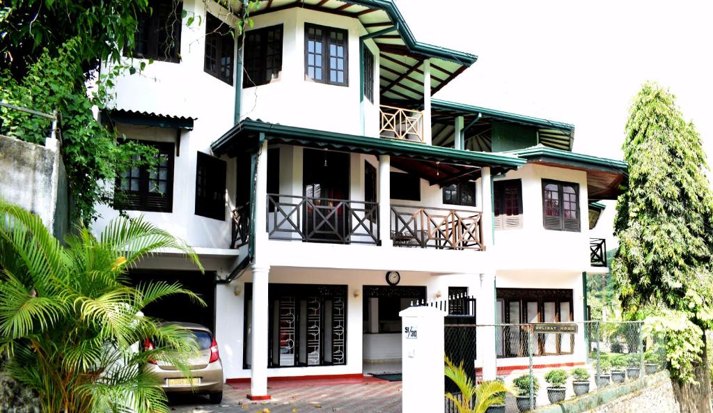 a white house with a green roof at Kandy Holiday Home in Kandy