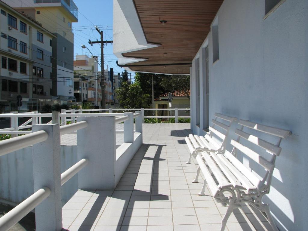 una fila de bancos blancos sentados en un balcón en Santoro Gali 210, en Florianópolis