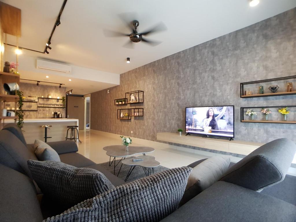 sala de estar con sofá y TV de pantalla plana en Southkey Mosaic by Asiapex, en Johor Bahru