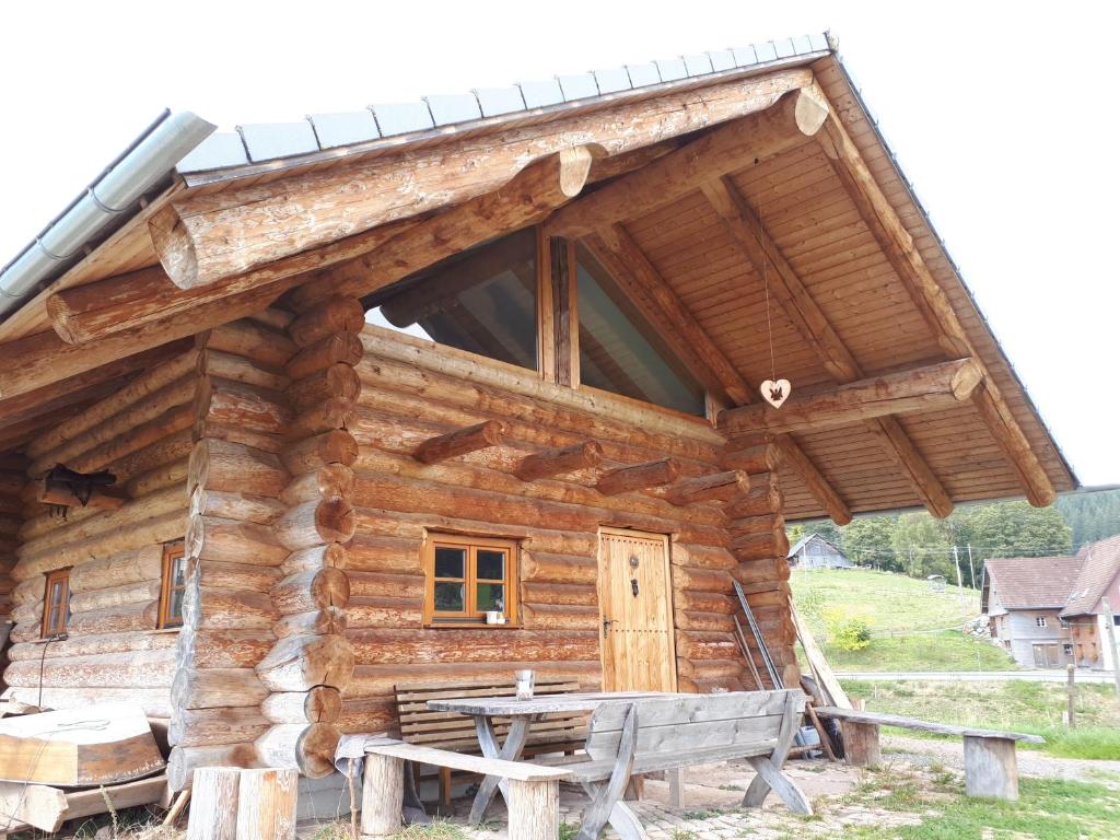 una cabaña de madera con una mesa de picnic delante de ella en Blockhaustraum en Titisee-Neustadt