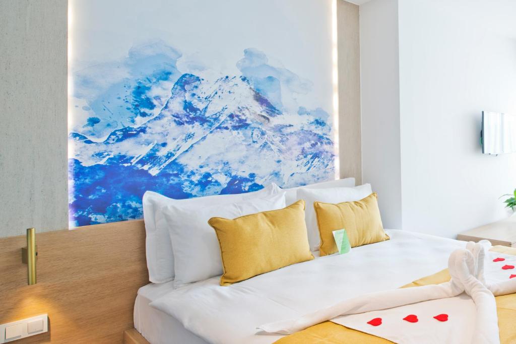 1 dormitorio con cama blanca y almohadas amarillas en Hotel 86 By Katipoğlu, en Izmir