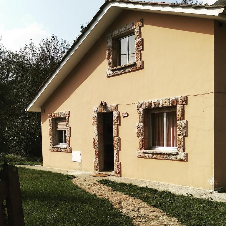 an old house with windows on the side of it at La Konerie in Cangas de Onís