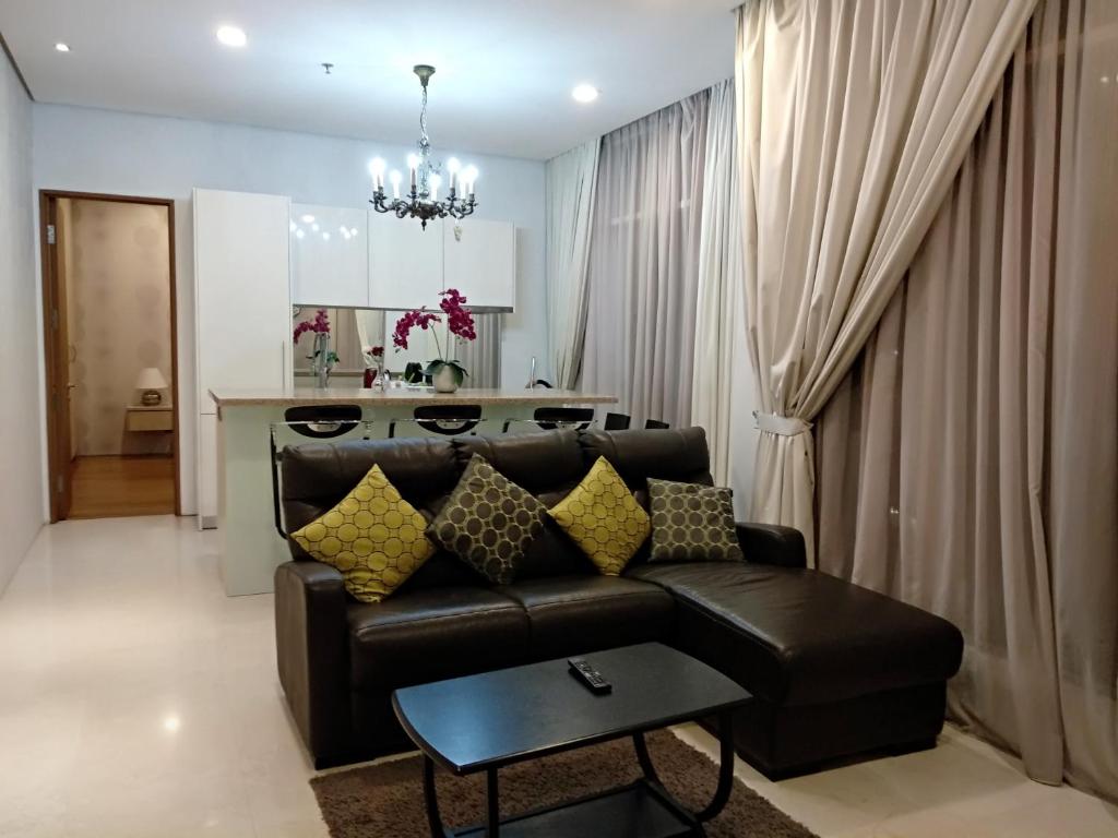 a living room with a leather couch and a table at Soho Suites KLCC Elite 2 in Kuala Lumpur