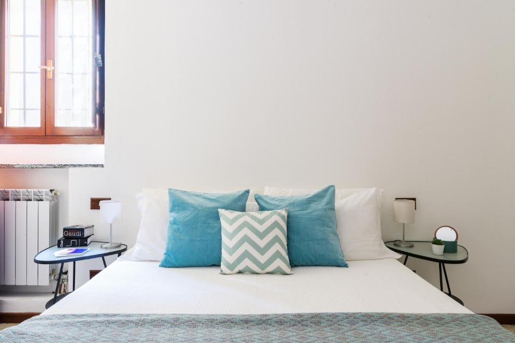 - une chambre avec un lit doté d'oreillers bleus et blancs dans l'établissement CASETTA GIALLA by ITALYVING, à Rho
