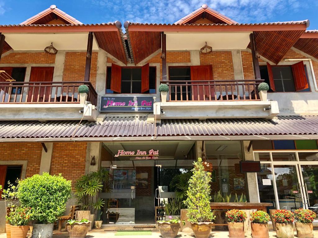 a building with potted plants in front of it at Home Inn Pai Garden in Pai