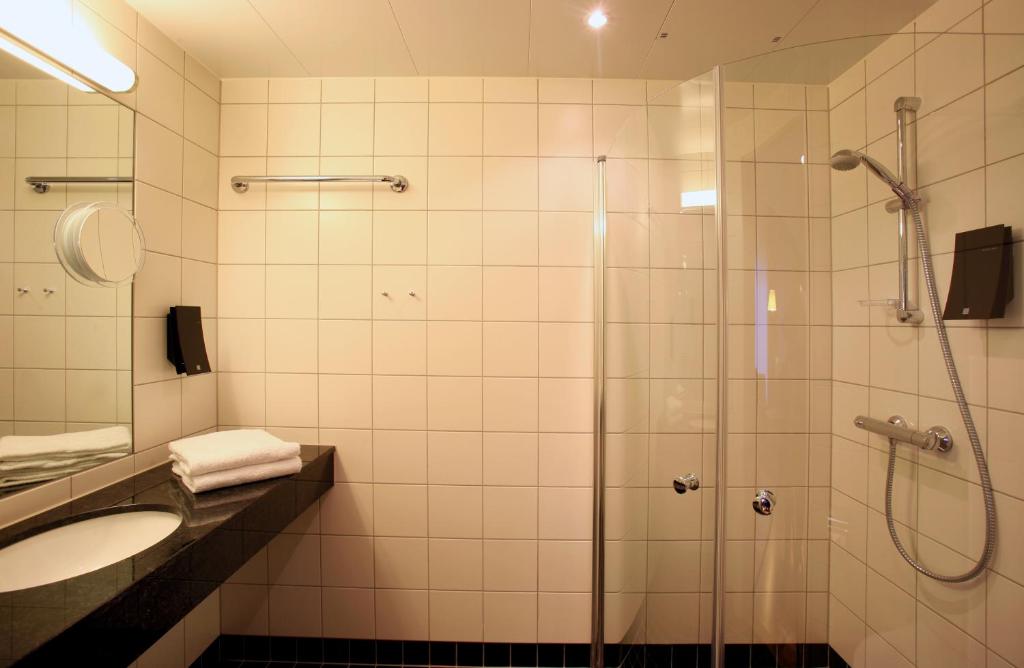 La salle de bains est pourvue d'une douche et d'un lavabo. dans l'établissement Thon Hotel Brønnøysund, à Brønnøysund