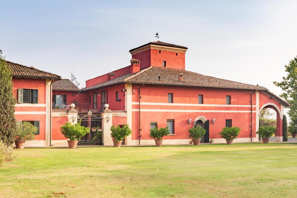 un gran edificio de ladrillo rojo con un patio de césped en Cà Palazzo Malvasia - BolognaRooms en Sasso Marconi