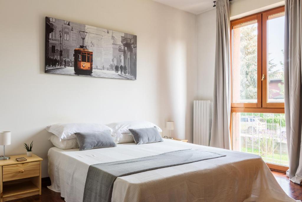 - une chambre dotée d'un lit avec une photo sur le mur dans l'établissement EXPO CITY - BALZAROTTI BUSINESS APARTMENT by ITALYVING, à Rho