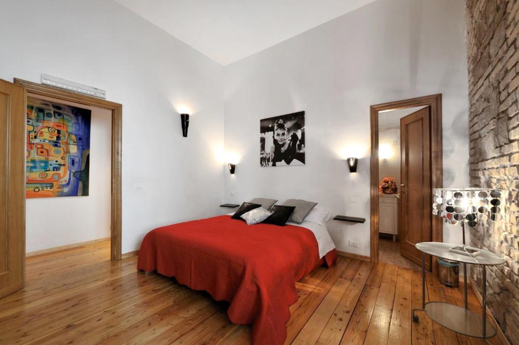 een slaapkamer met een bed met een rode deken bij Caesar's Rooms in Rome