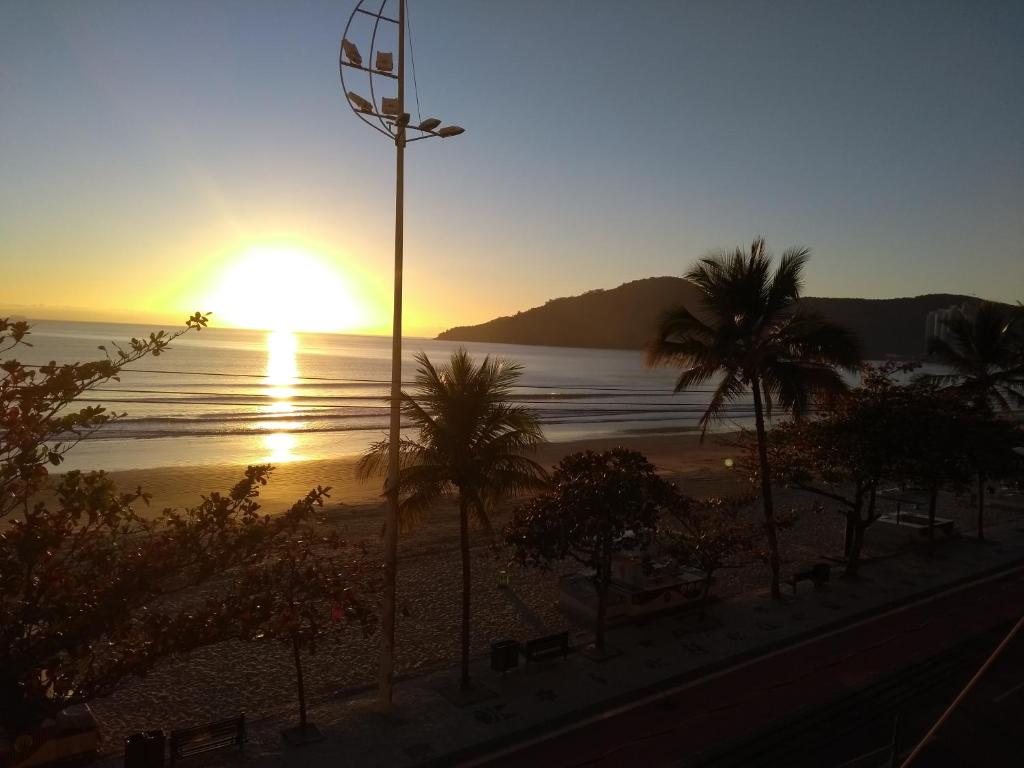puesta de sol sobre una playa con palmeras y luz de la calle en APTO. BEIRA MAR EM BAL. CAMBORIU, en Balneário Camboriú