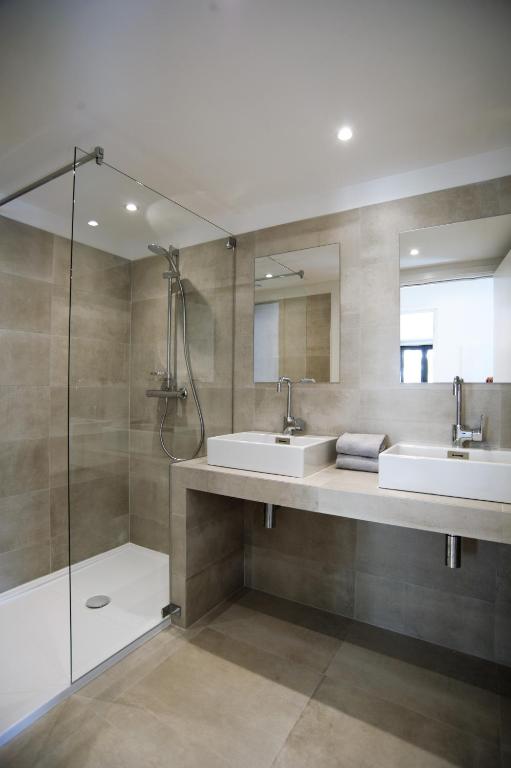 a bathroom with two sinks and a shower at Les Appartements du Port in Bonifacio