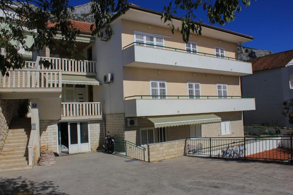 un gran edificio de apartamentos con balcones y aparcamiento en Apartments Pino, en Makarska