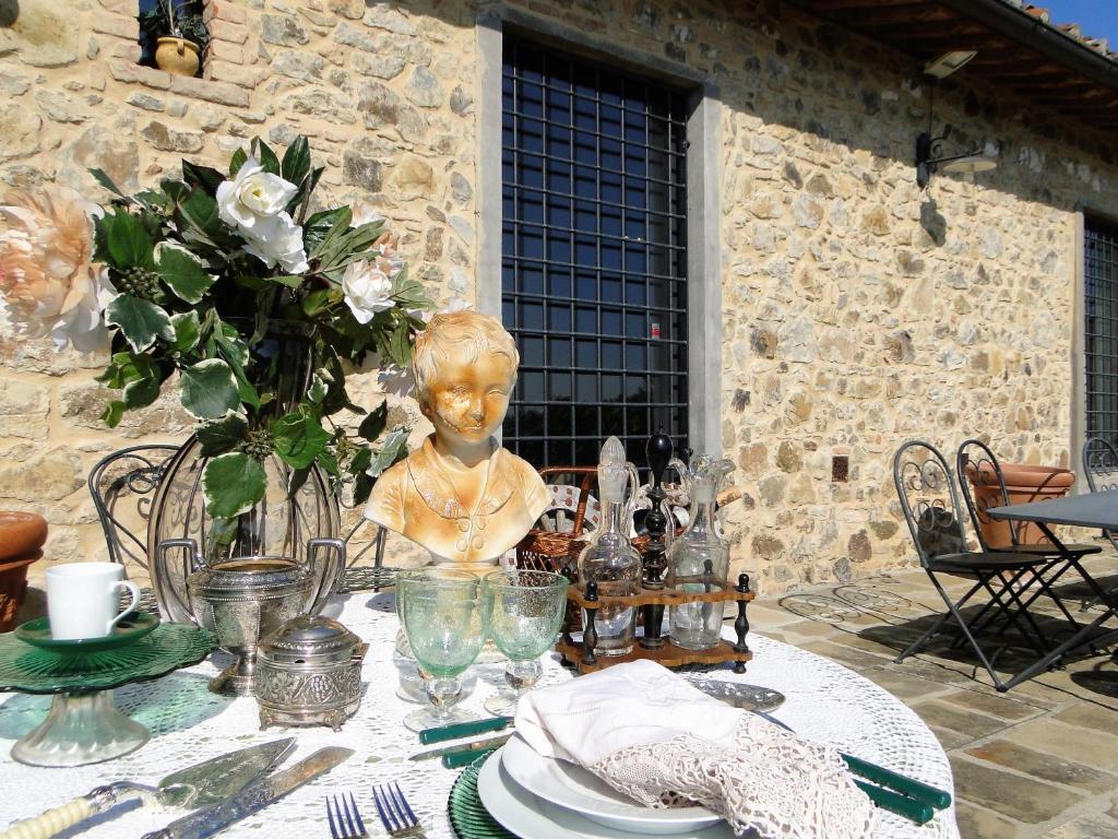 einen Tisch mit einer Blumenvase und einer Statue darauf in der Unterkunft Casa Carmignano in La Serra