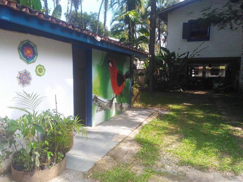 una pintura de un pájaro al lado de una casa en Hostel Terra das Tribos, en Ubatuba