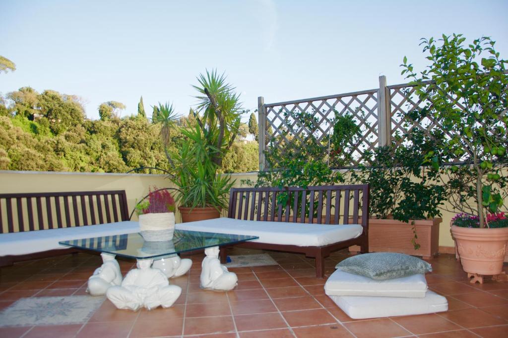 a patio with a table and benches and plants at La Terrazza di Isabel in Rome