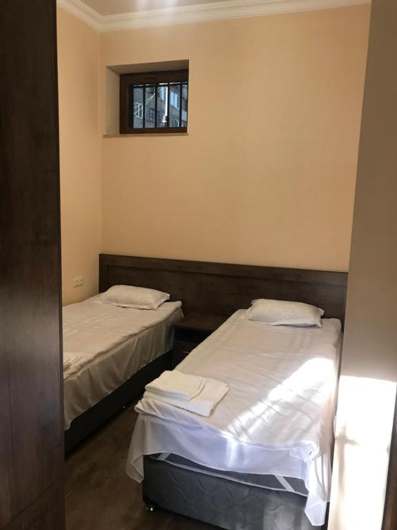2 Betten in einem kleinen Zimmer mit Fenster in der Unterkunft Guest house Abovyan street in Yerevan