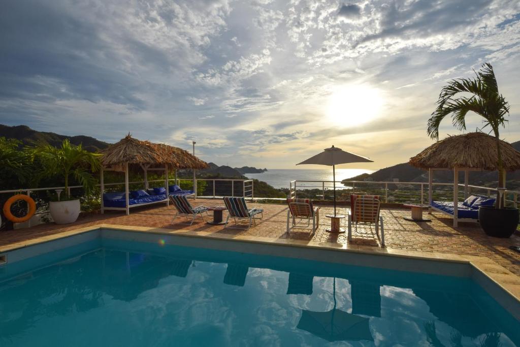 a pool at a resort with chairs and umbrellas at Casa Relax - Adults Only in Taganga