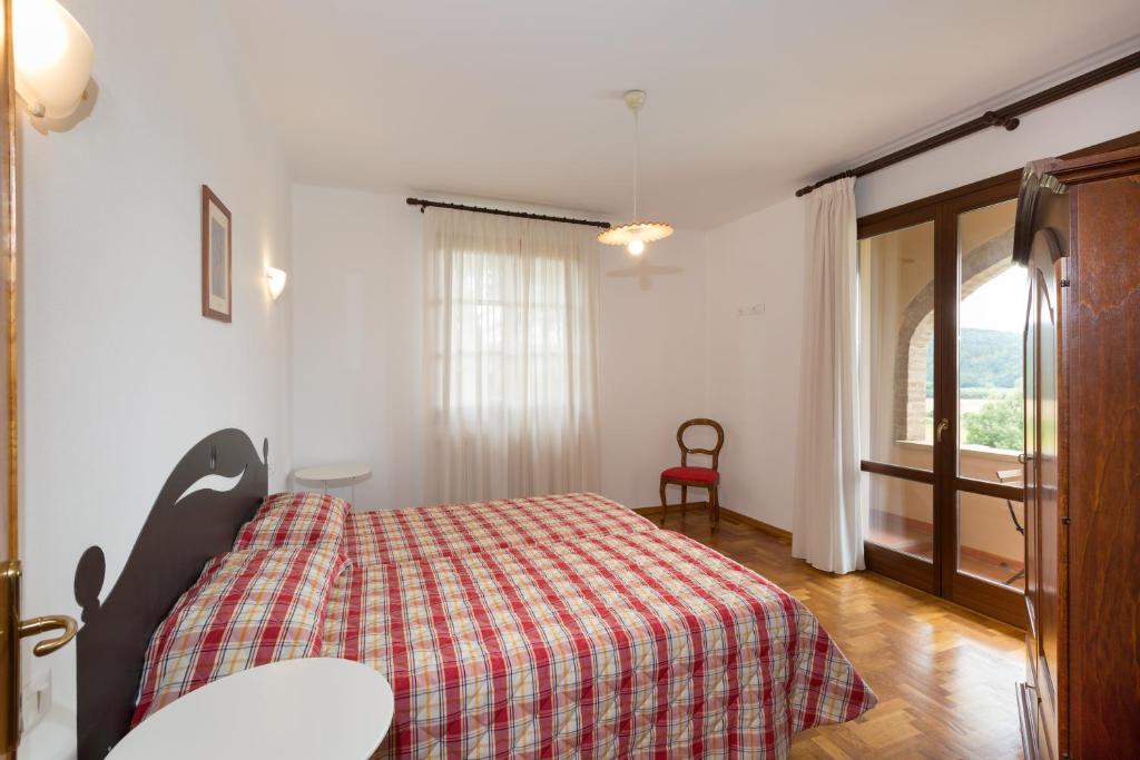 une chambre avec un lit avec une couverture à carreaux dans l'établissement VILLA LIGUSTRO, à Riparbella 21 autres photos