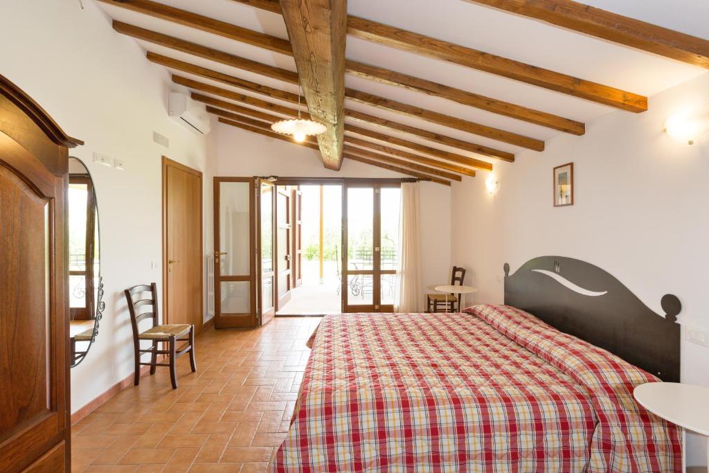 une chambre avec un lit avec une couverture à carreaux dans l'établissement VILLA LIGUSTRO, à Riparbella