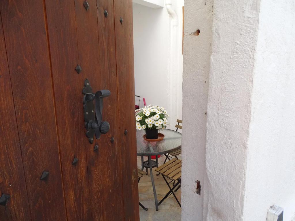 Old Navy House في بادالونا: باب يؤدي إلى طاولة مع إناء من الزهور