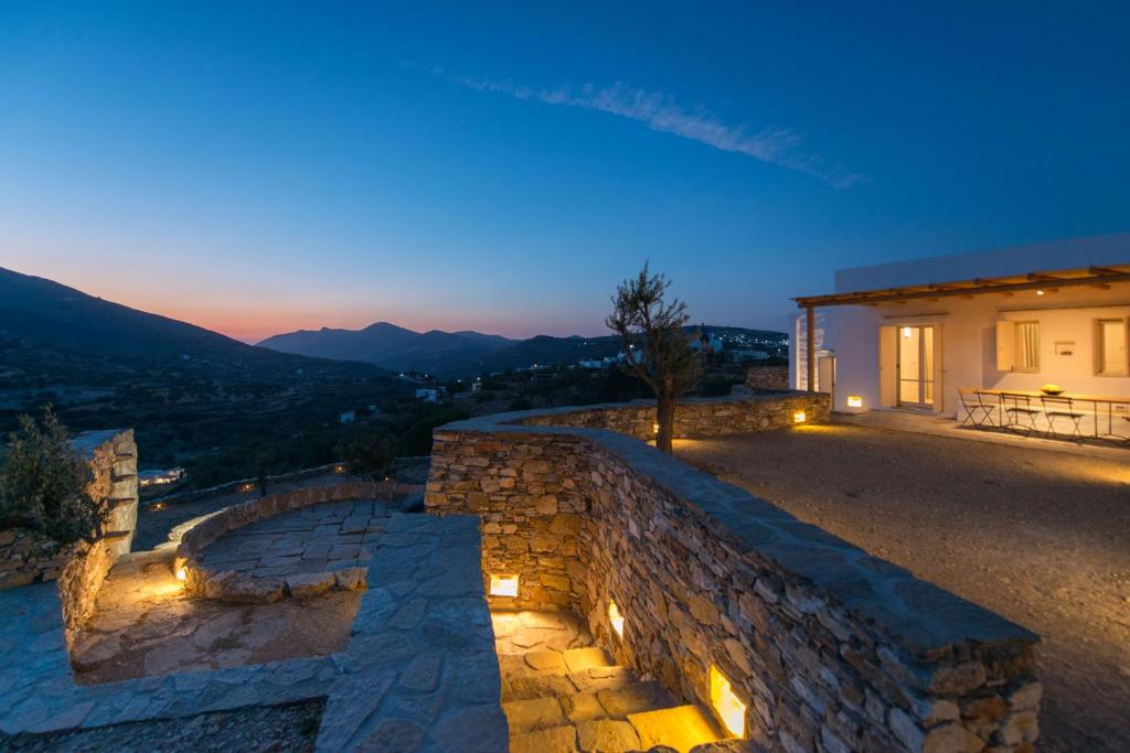 a house with a stone wall with lights on it at Katavati - 2 Semi-detached Houses in Apollonia
