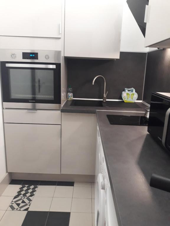 a kitchen with white cabinets and a sink at Palm beach Cannes Azur in Cannes