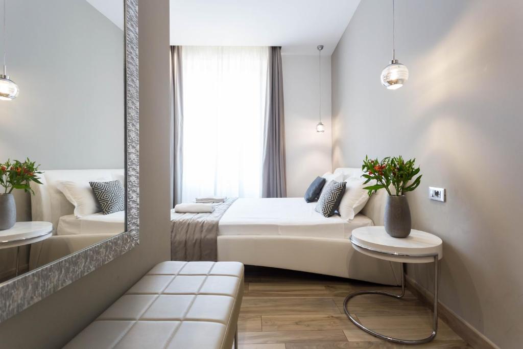 ミラノにあるApartHotel Duriniのベッドと鏡が備わるホテルルーム