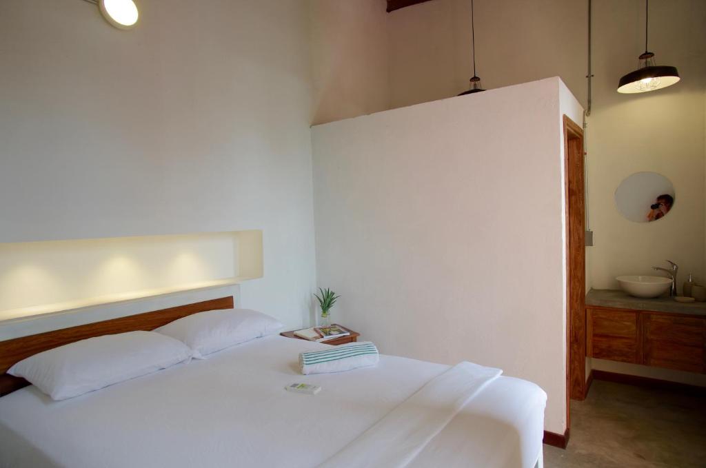 a bedroom with a white bed and a sink at Casa Tunido in Santa Marta