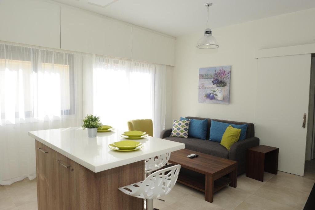 een keuken en een woonkamer met een tafel en een bank bij By The Way Apartment in Larnaka