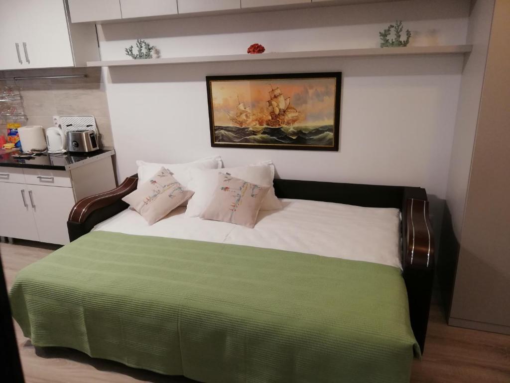 Un dormitorio con una cama verde y blanca con almohadas en Kolonaki Domus Apartment en Iaşi