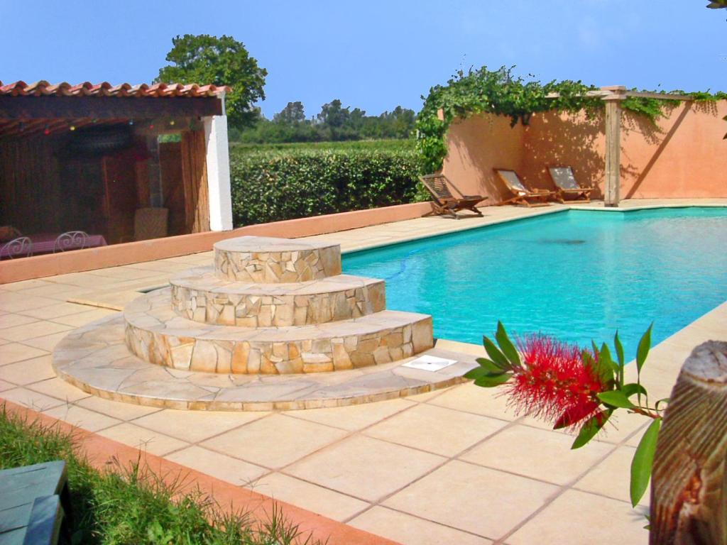 a swimming pool with a fountain in a yard at Chambres d'hôtes Domaine de Beaupré in Narbonne