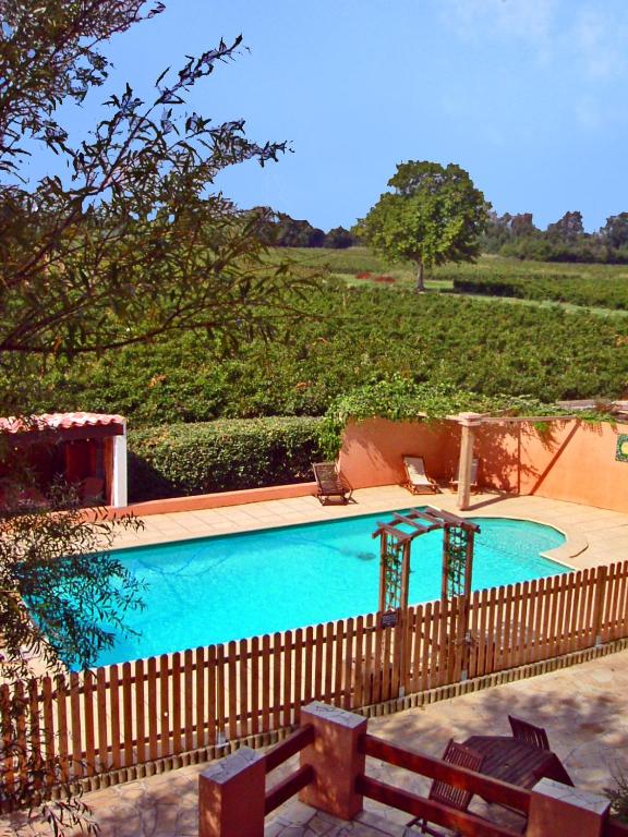 una gran piscina azul con una valla de madera en Chambres d&#39;hôtes Domaine de Beaupré, en Narbona