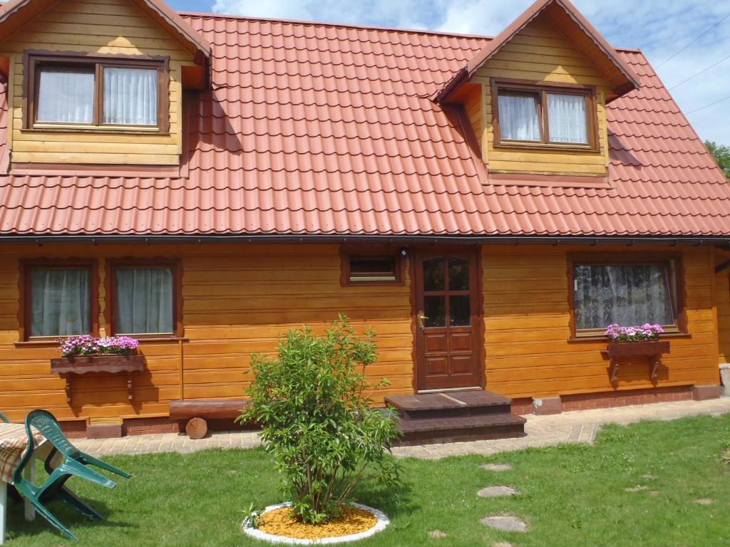 a wooden house with a red roof at Kraina Szczęśliwości in Zawoja