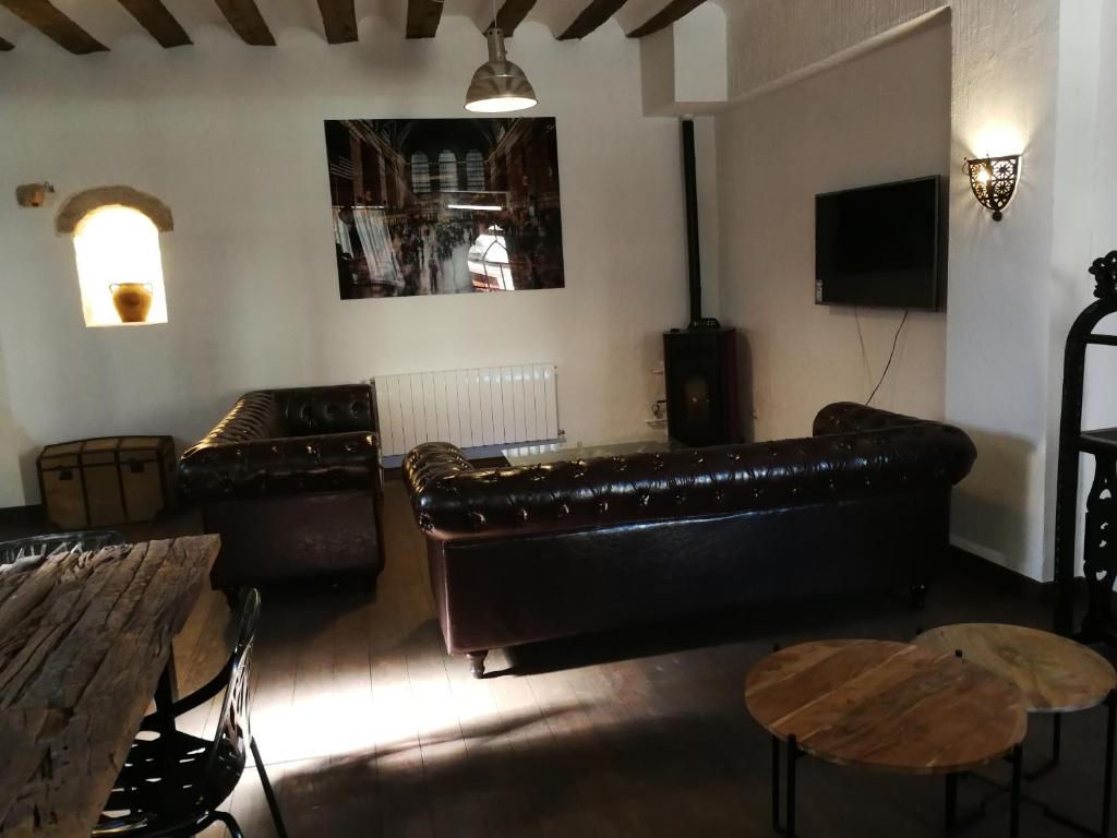 a living room with a leather couch and tables at BAVIECA-MARIMEDRANO 12 in Medinaceli