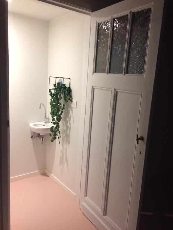 a bathroom with a white door and a sink at Nelly in Ypres