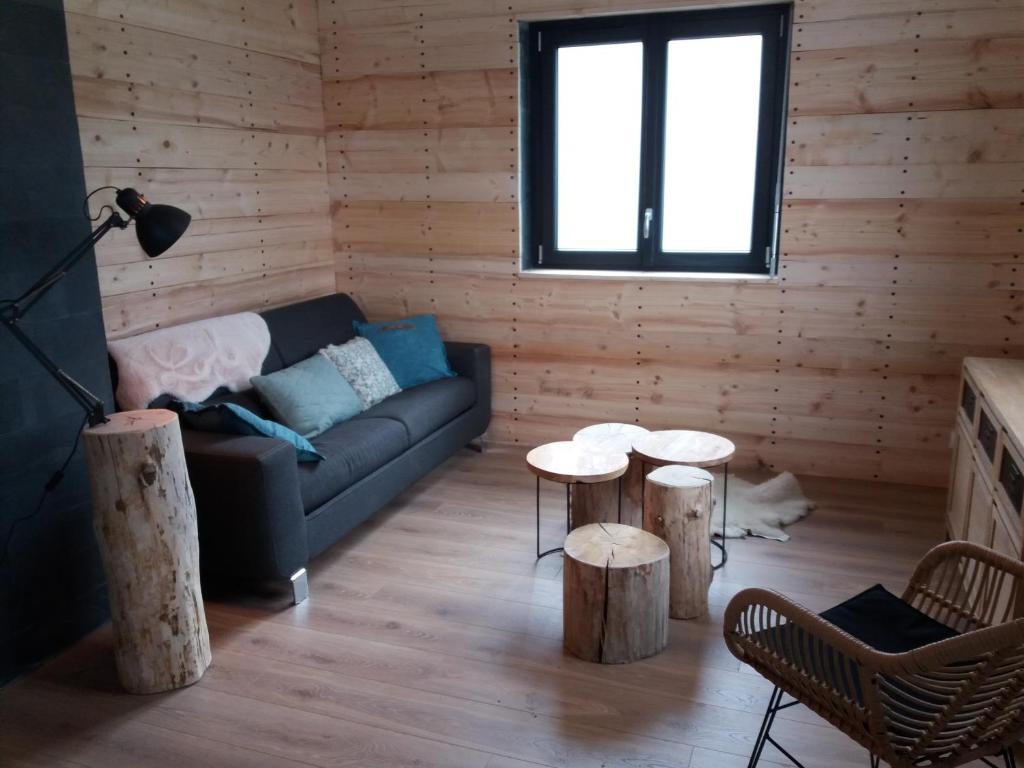 ein Wohnzimmer mit einem Sofa und 2 Tischen in der Unterkunft Chalet du Toit Vosgien in Gérardmer