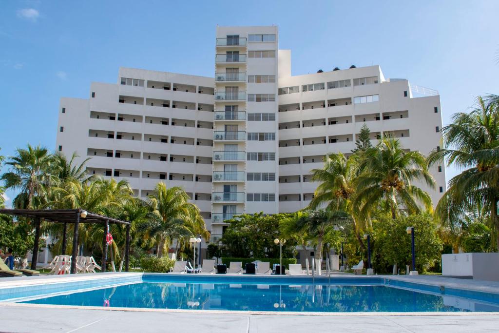 a swimming pool in front of a large building at Hotel Calypso Cancun in Cancún