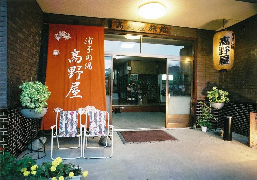 an entrance to a building with two chairs and a door at Takanoya in Yuzawa
