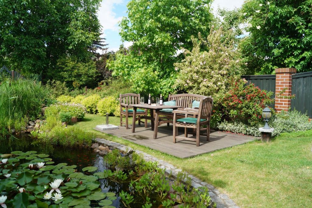 a patio with a table and chairs next to a pond at Spreewald-Domizil in Lübbenau