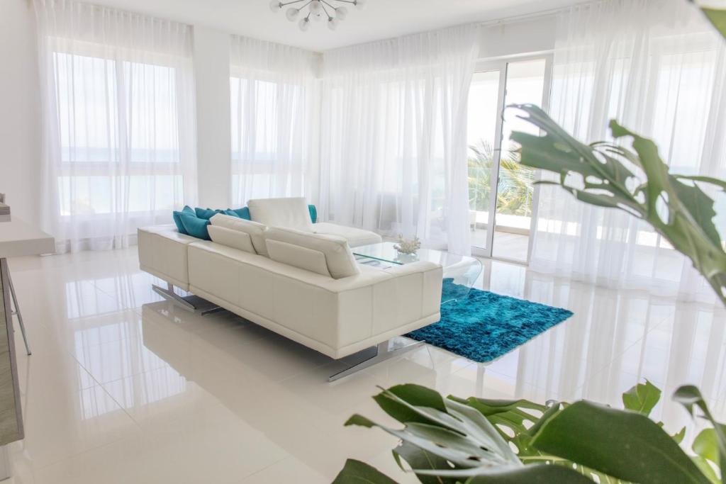 sala de estar con sofá blanco y alfombra azul en Sea Winds with Direct Ocean Views, en Cabarete