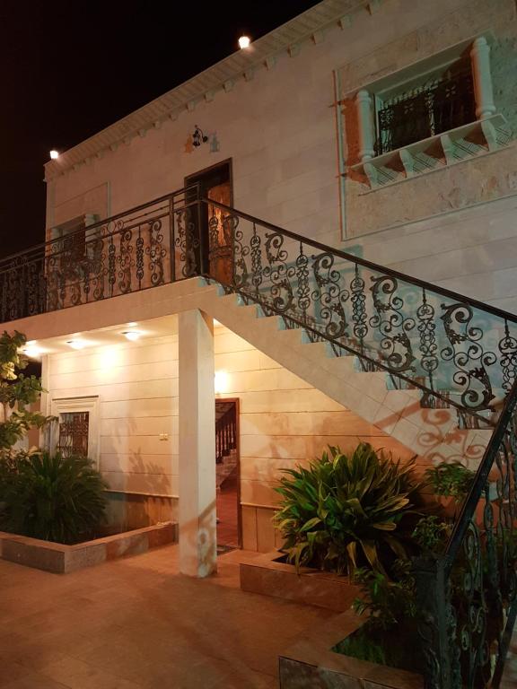 Una escalera que conduce a una casa por la noche en Villa Ar Rayis Beach, en Rayyis