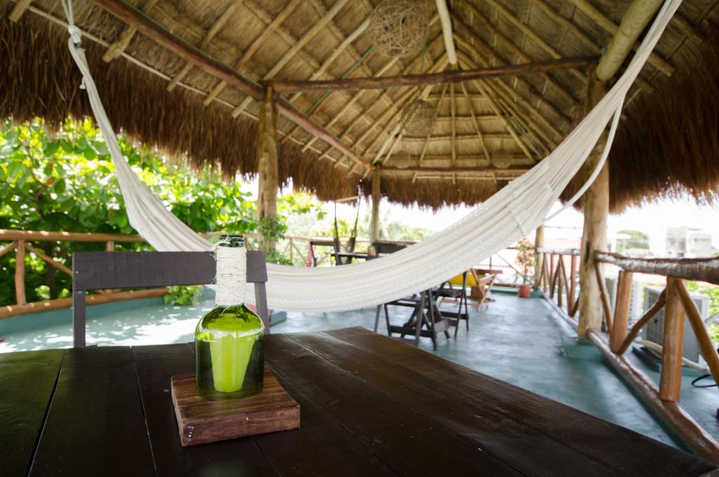 einen Holztisch mit einer Flasche auf einer Hängematte in der Unterkunft Casa Almendro in Tulum