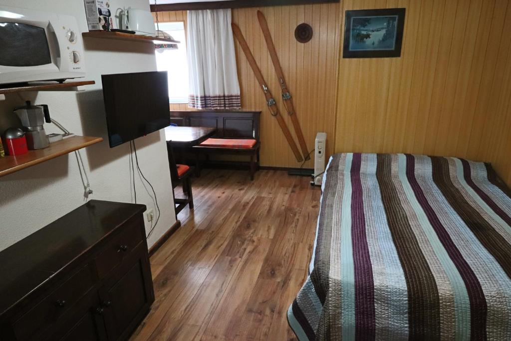 een slaapkamer met een bed, een bureau en een tv bij Presidente con vistas al Veleta in Sierra Nevada