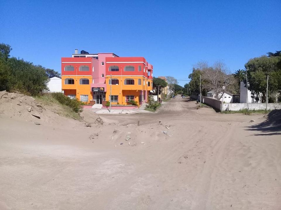 una casa sentada al lado de un camino de tierra en Médanos Hotel en San Clemente del Tuyú