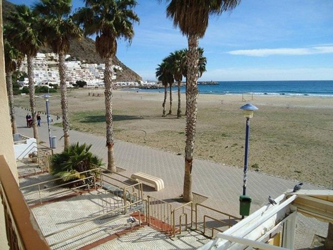 Una vista de una playa con palmeras y el océano. en Apartamento en la Playa de San José-sjjc, en San José