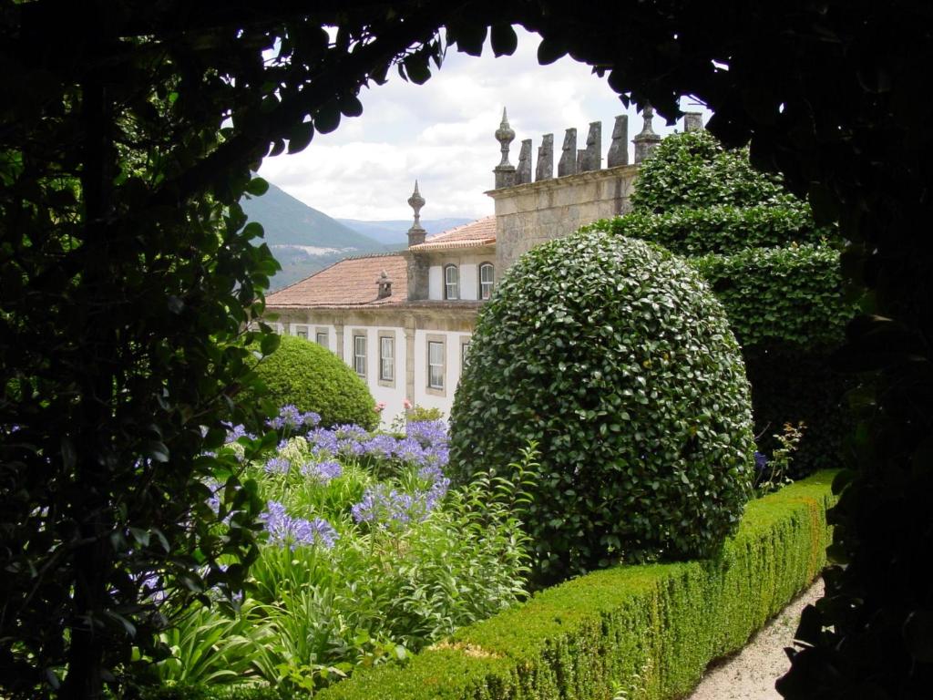 uma vista para um jardim com um edifício e flores em Casa do Campo - Turismo de Habitação em Celorico de Basto