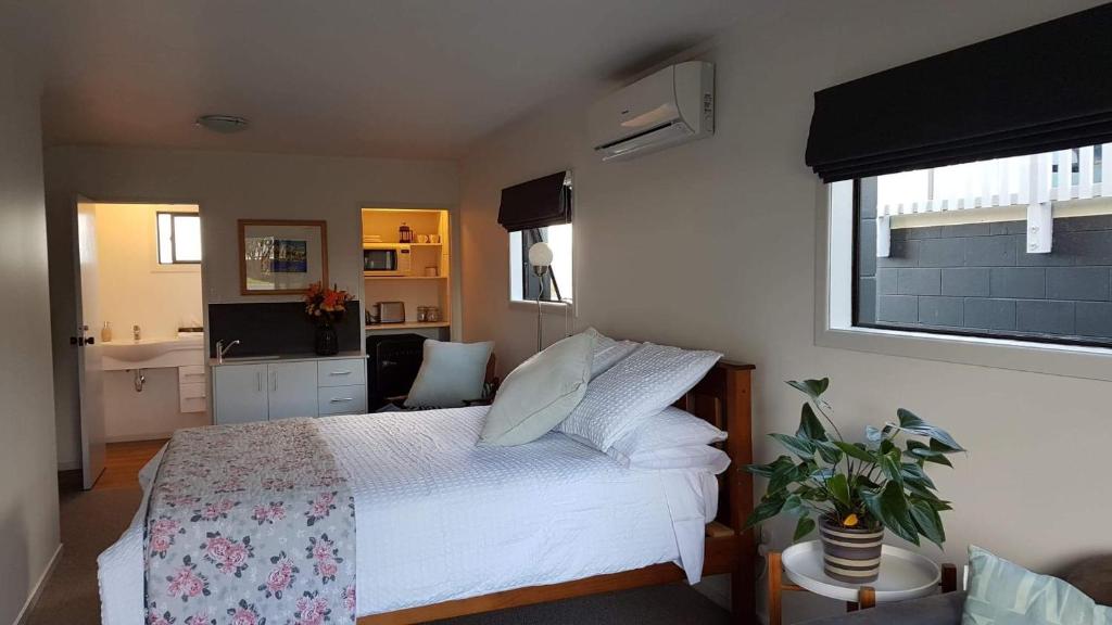 a bedroom with a white bed and a window at Long St Studio in Raglan