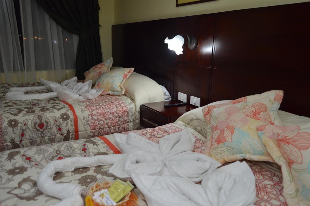 a hotel room with two beds with towels on them at Balcones del Río Hotel in Latacunga